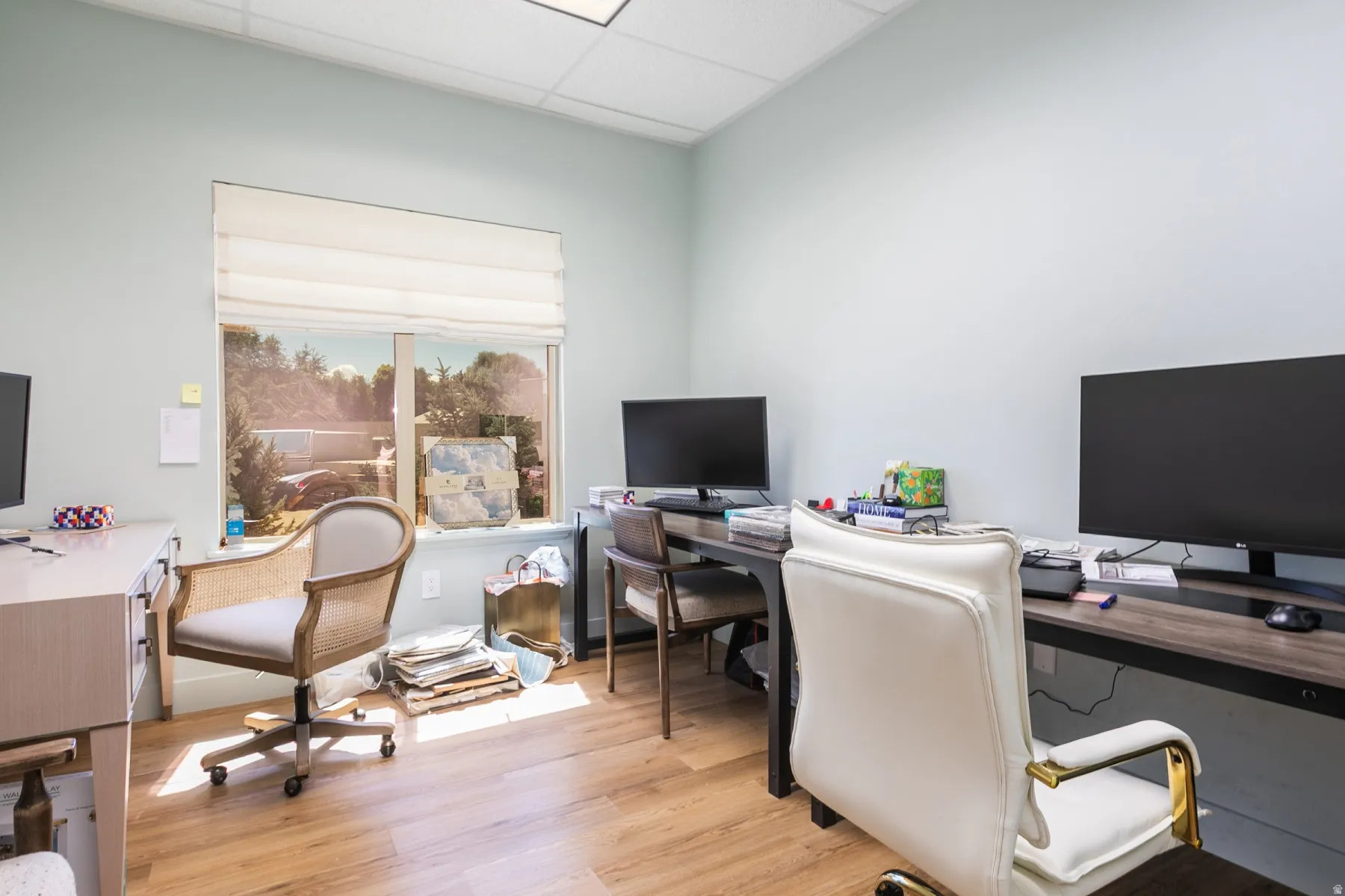 Wood-finish flooring, recessed lighting, and a large window with privacy shades