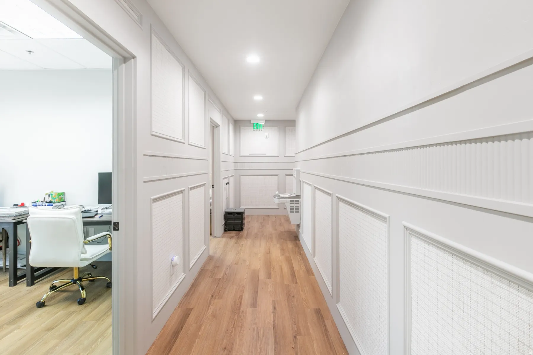 Hallway featuring wainscoting with patterned panels and beadboard accents, wood-finish flooring, recessed lighting, and white walls
