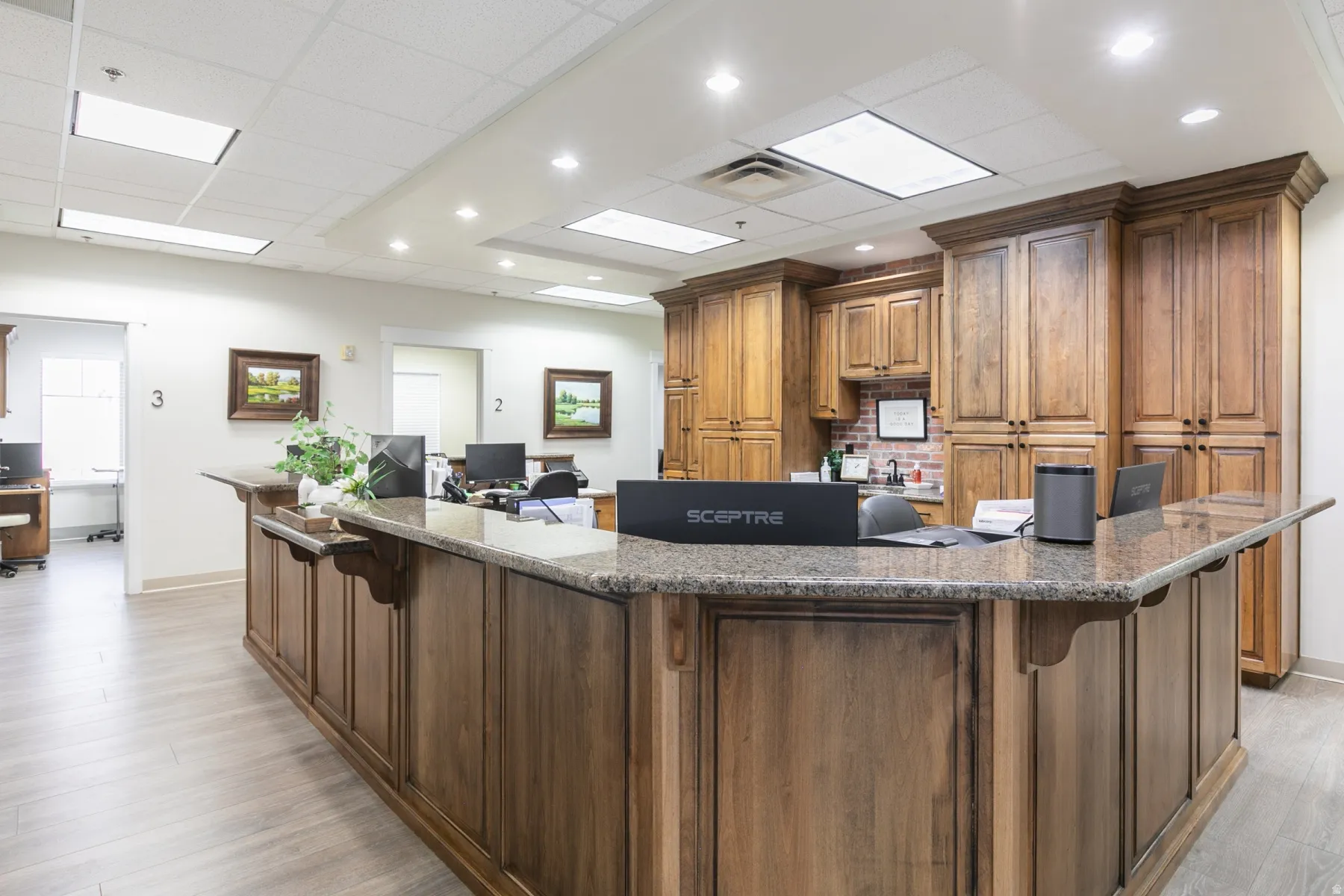 Expansive reception desk with a stone-finish countertop and wood-paneled base