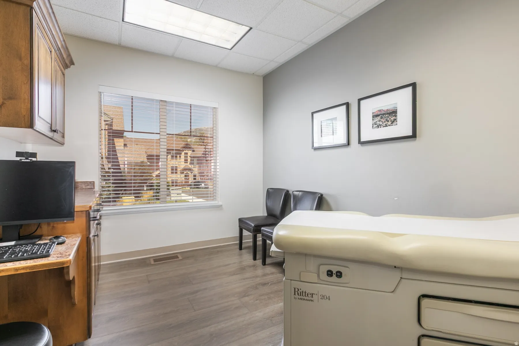 Wood-finish flooring with a large window, built-in cabinetry, and neutral wall tones