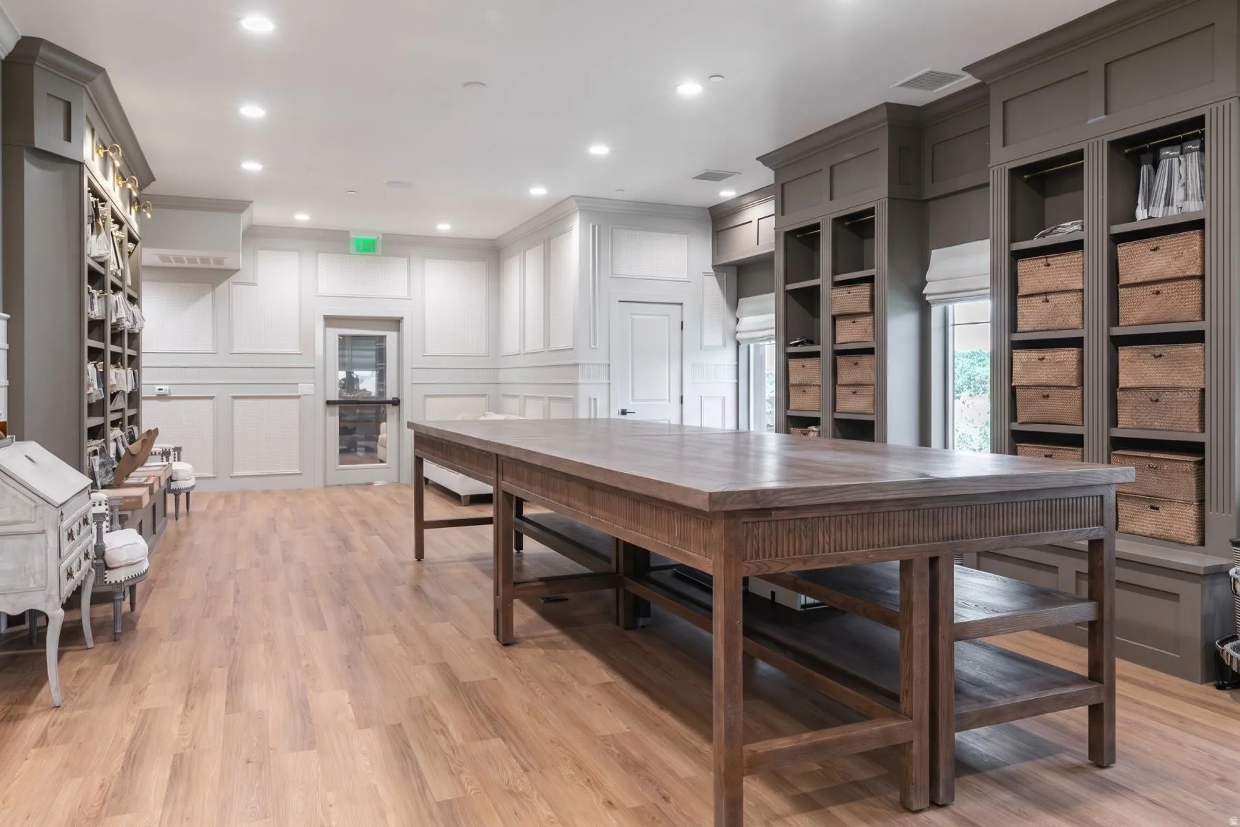 Wood-finish flooring, recessed ceiling lighting, extensive built-in shelving, wainscoting, and large windows