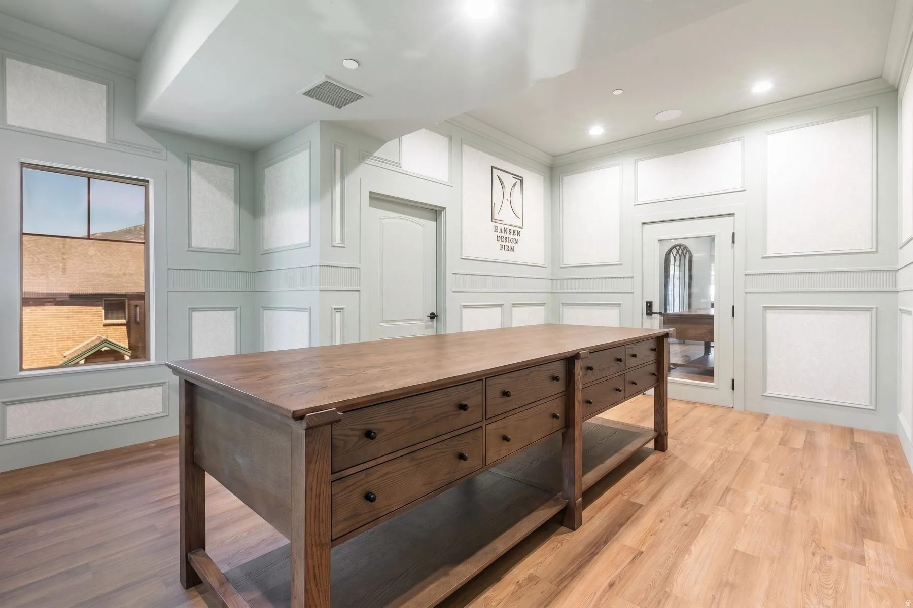 Wood-finish flooring, recessed lighting, and intricate wall paneling