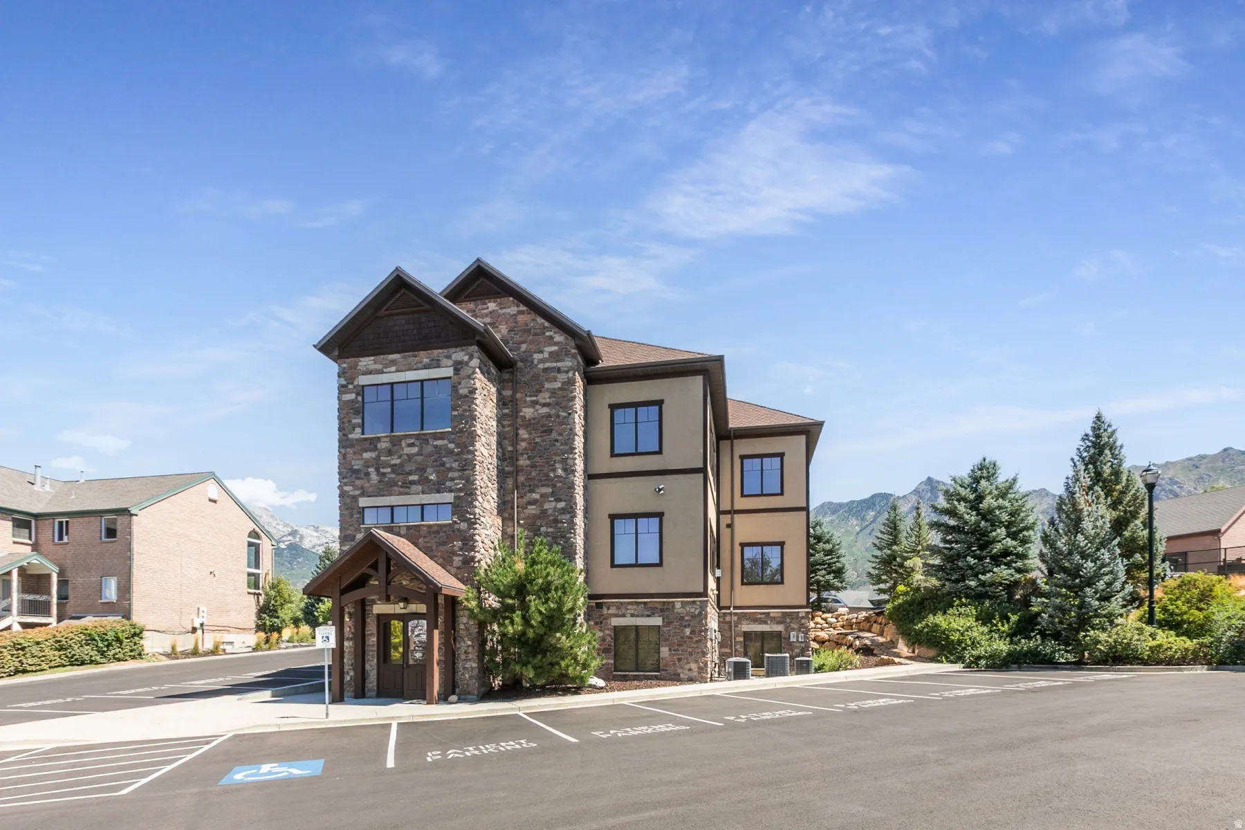 Stone and stucco exterior with dark trim windows