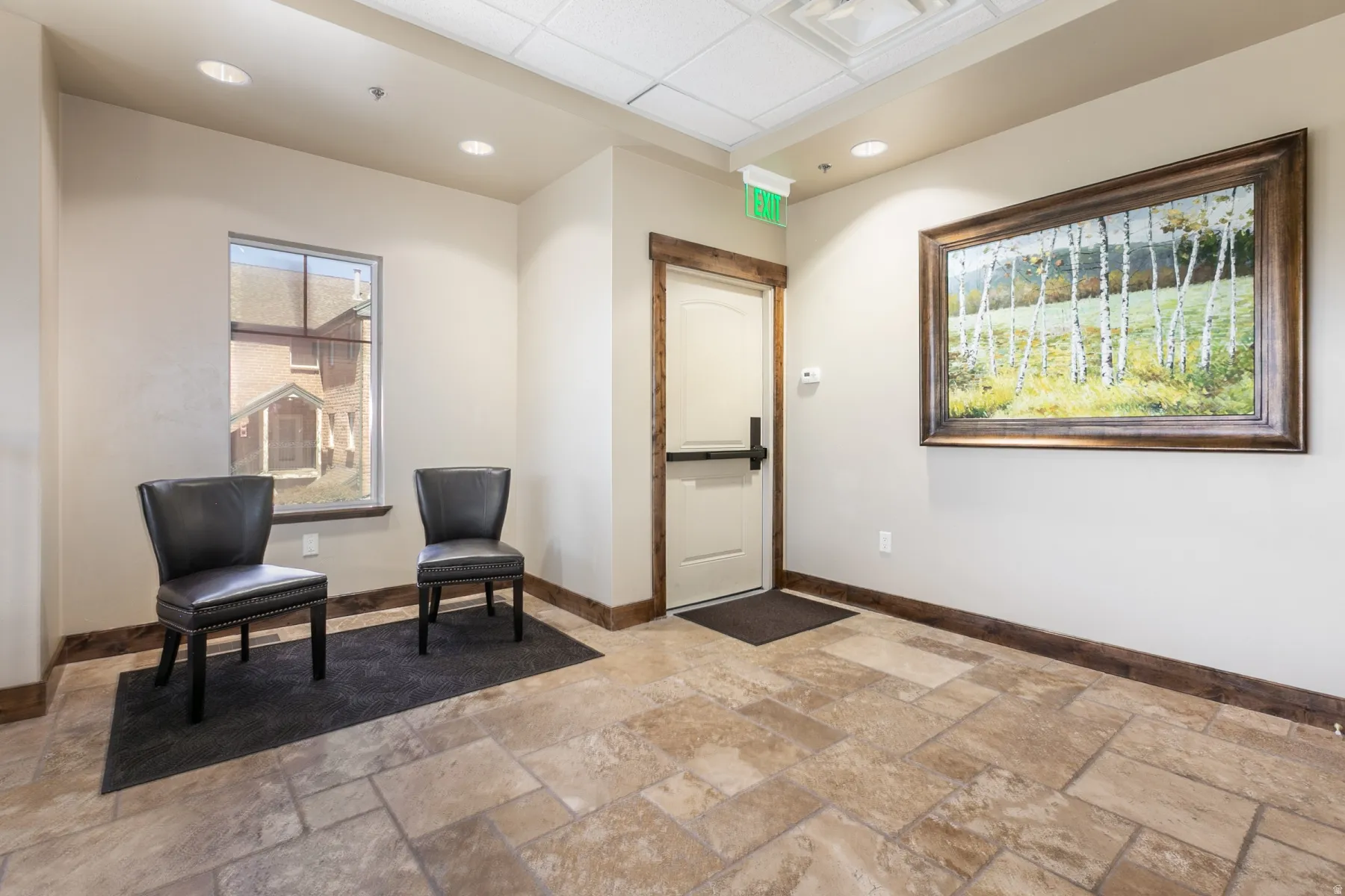 Large format tile flooring, recessed lighting, wood trim details, and a solid core door