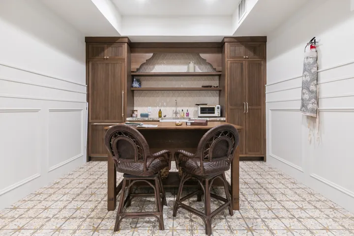 Built-in wood cabinetry with shelving, patterned tile flooring, paneling and chair rail molding, and recessed lighting