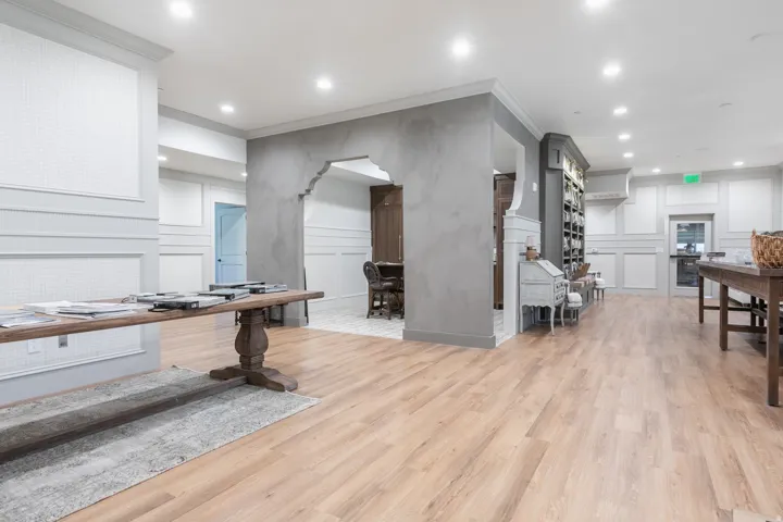 Wood-finish flooring, recessed lighting, arched entryway, and wainscoting paneling