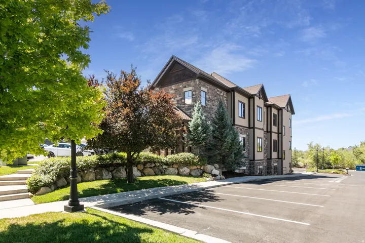 Multi-level building with stone and siding exterior, gabled rooflines, and multiple windows