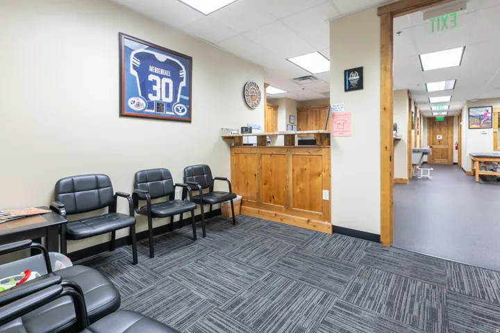Reception area featuring wood-paneled counter, recessed lighting, and patterned carpet