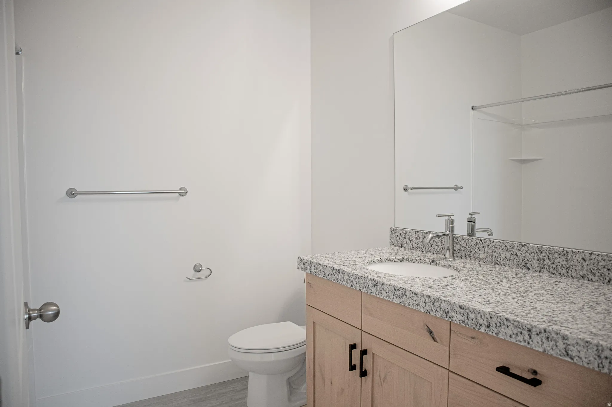 Full secondary bath with stained wood cabinets and granite slab countertops.