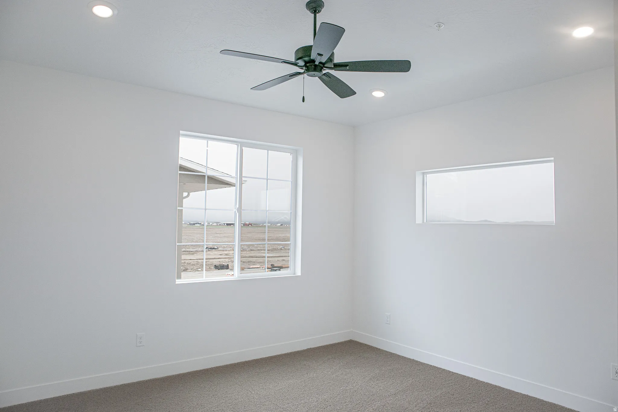 Primary bedroom with vaulted ceiling, ceiling fan and great views.