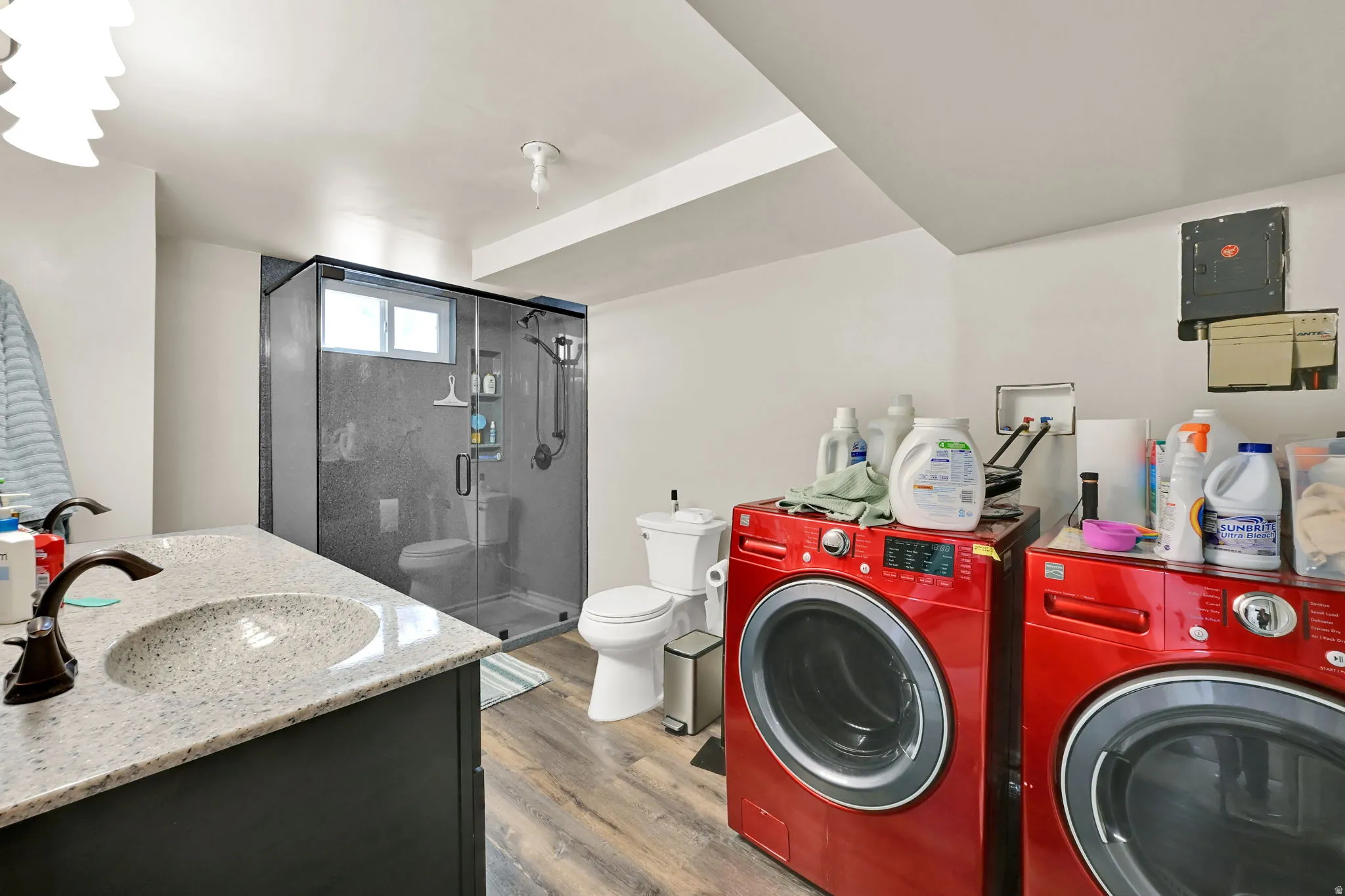 Vanity with light-colored countertop, vessel sink, and dual faucets