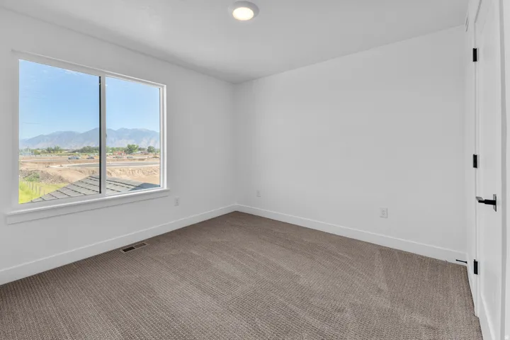 Spacious room featuring neutral paint, gray carpet, a large window, and recessed lighting