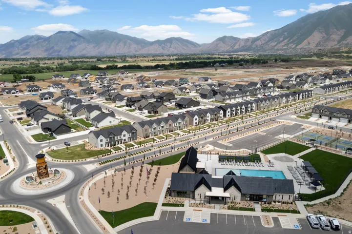 Community amenity center with an outdoor swimming pool, tennis courts, and contemporary residential architecture