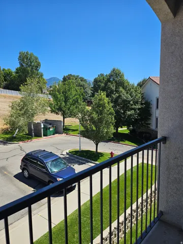 Exterior balcony featuring black metal railings and stucco siding
