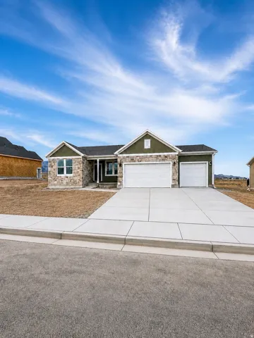 Exterior with stone veneer accents, two-car garage, concrete driveway, and covered porch entry