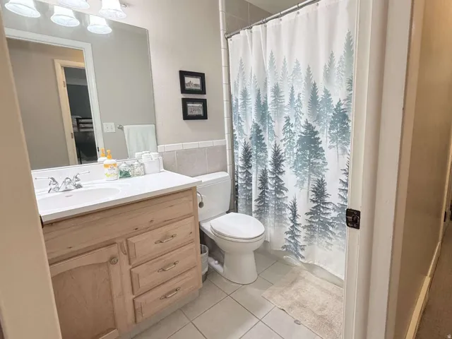 Single vanity with integrated sink, wood-finish cabinetry, and a shower-tub combination