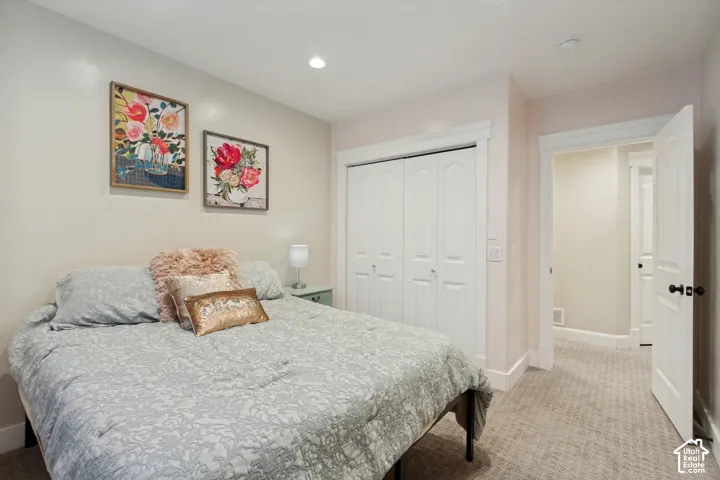 Recessed lighting, carpeted flooring, white bi-fold closet doors, white trim, and a white interior door