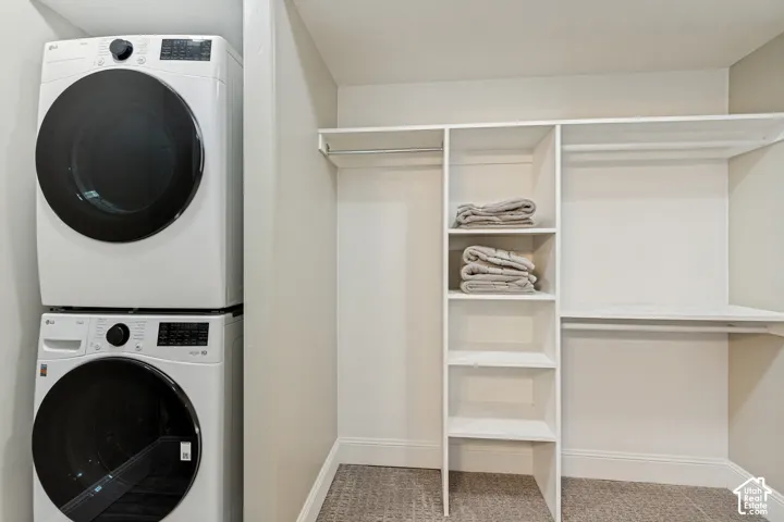 Built-in white shelving, integrated hanging rods, and a stackable washer and dryer unit