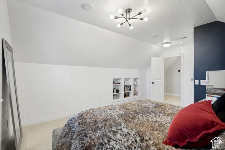 Built-in shelving, angled ceiling, white paneled door, and recessed lighting