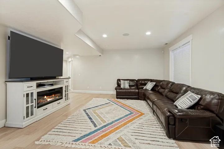 Recessed lighting, wood-finish flooring, and white window blinds