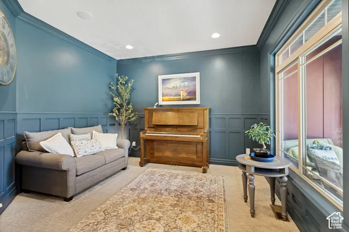 Wall paneling with crown molding, recessed lighting, and a large window with multiple panes