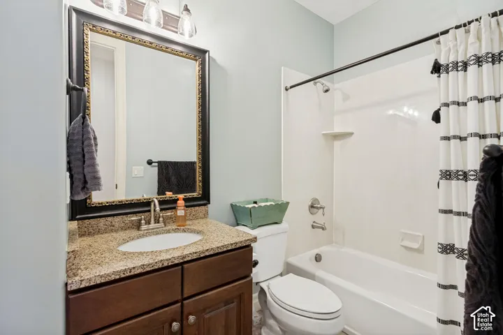 Vanity with granite countertop, integrated sink, and wood-finish cabinetry