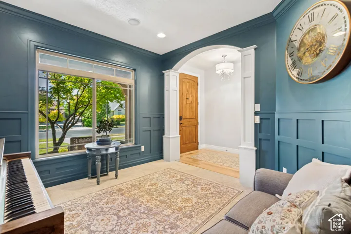 Board and batten wall treatment, arched entry, hardwood flooring, recessed lighting, and large window