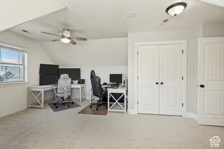 Carpeted room featuring a ceiling fan, window, recessed lighting, and two paneled doors