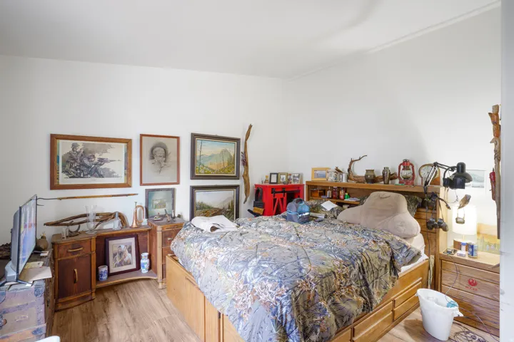 Wood-finish flooring with white walls and a built-in storage bed