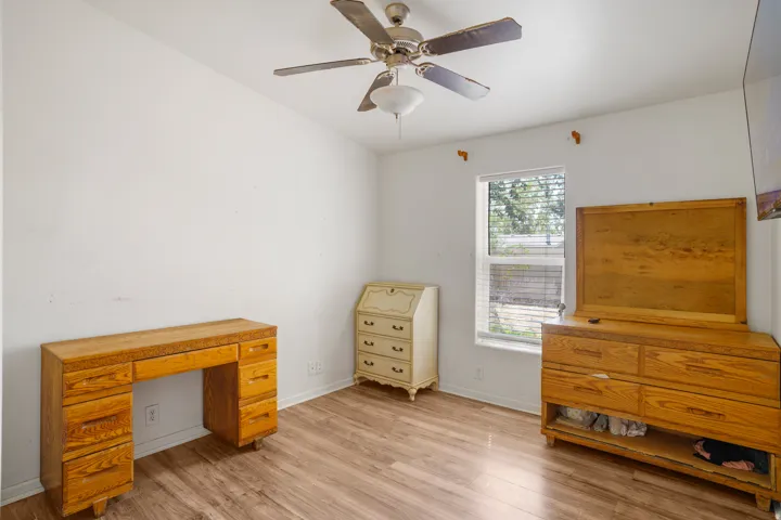 Wood-finish flooring with a ceiling fan and overhead lighting