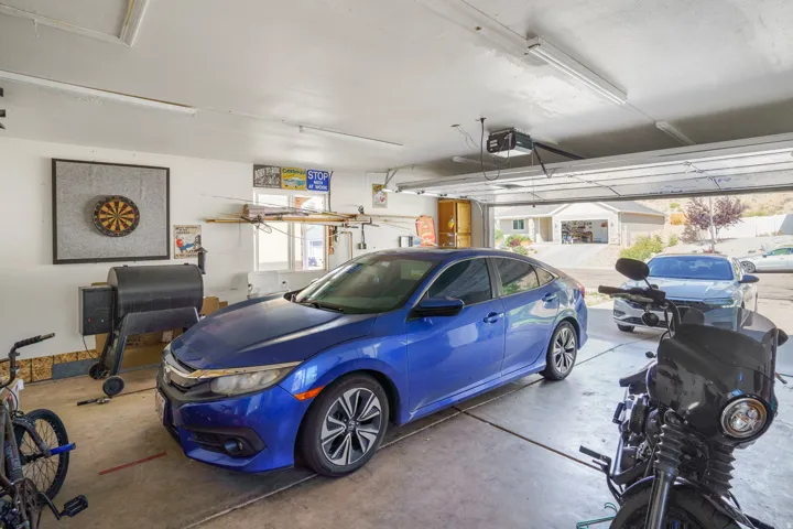 Attached garage with concrete flooring, fluorescent lighting, and an automatic garage door opener