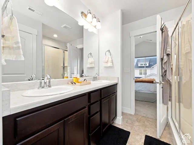 Double vanity with dark wood-finish cabinetry, chrome fixtures, and a light-toned countertop