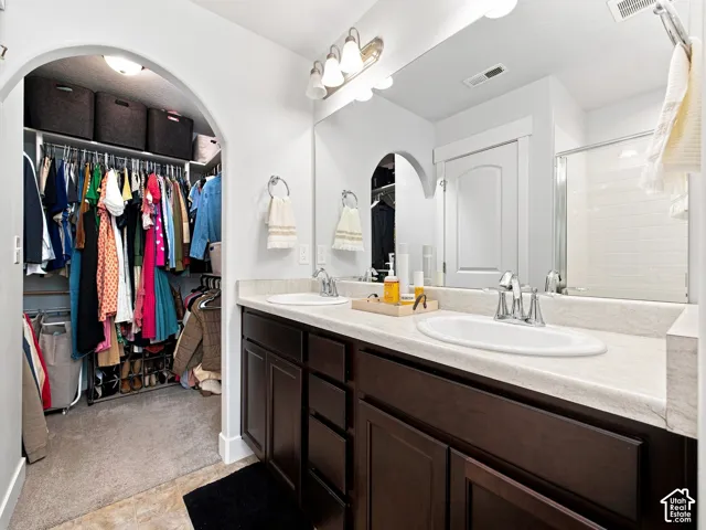 Dual sink vanity with dark wood-finish cabinetry and a light-toned countertop