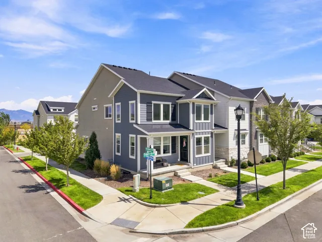 Townhome exterior with a dark gray roof, blue and gray siding, and a covered porch
