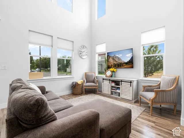 Vaulted ceilings, abundant natural light, wood-finish flooring, white walls, and a built-in media cabinet