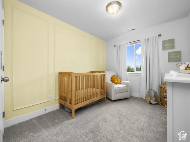 Recessed lighting, light-colored wall paneling, a large window, and light gray carpeting
