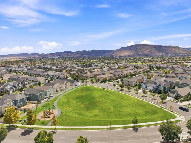 Expansive green space with a playground, surrounded by residential properties and paved roads
