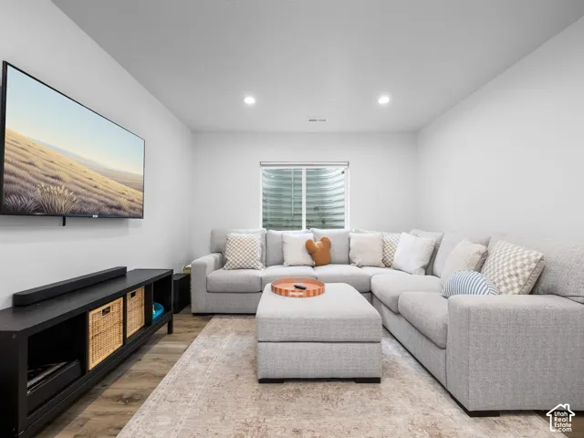 Recessed ceiling lighting, wood-finish flooring, and a window with blinds