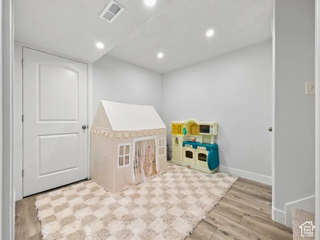 Recessed lighting, wood-finish flooring, white paneled door, and light gray wall finish