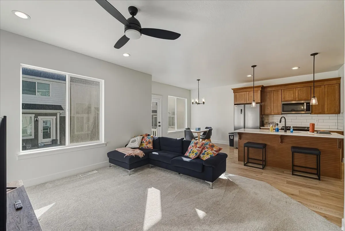 Open-concept living area with recessed lighting and a ceiling fan