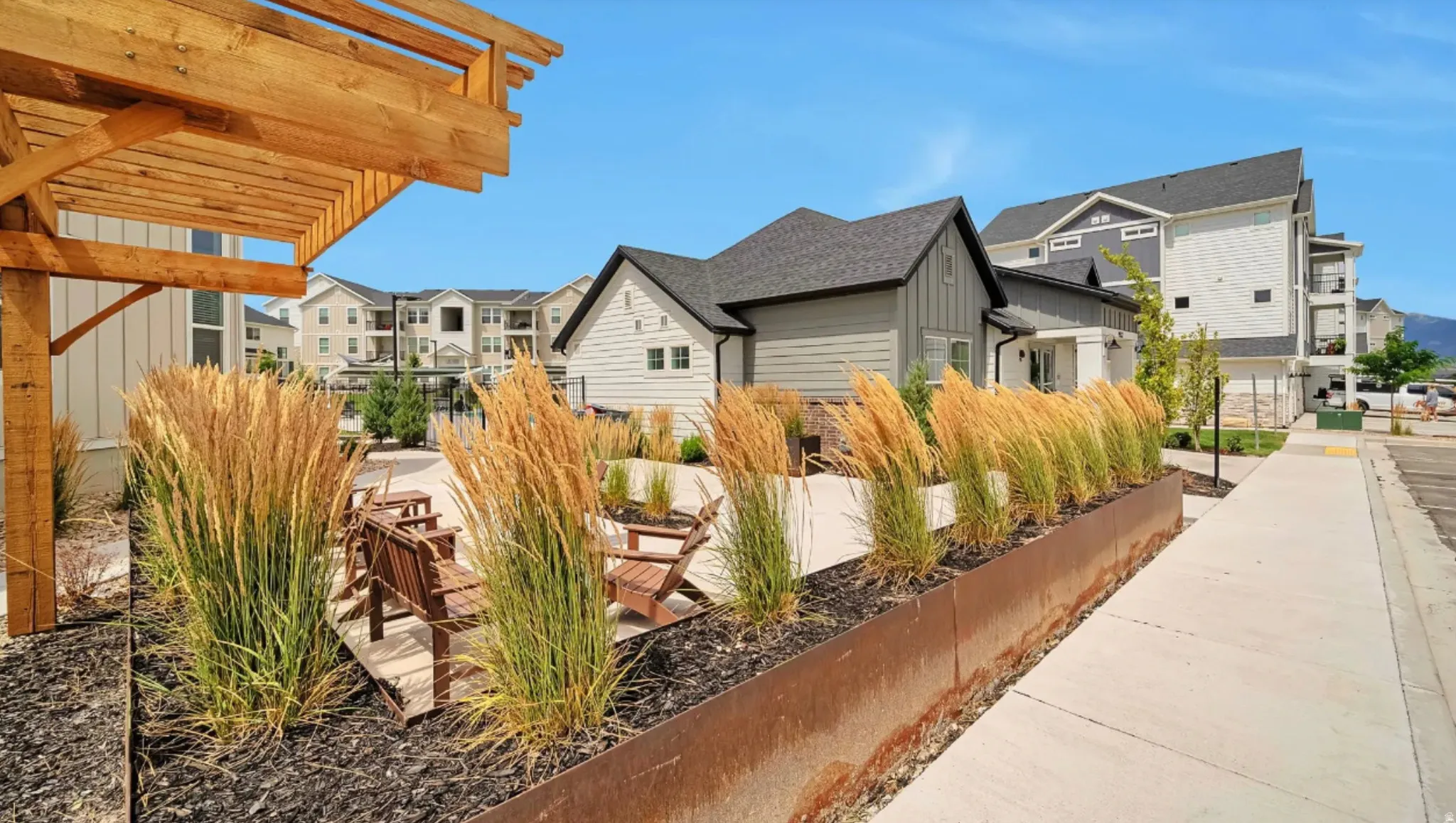 Landscaped courtyard featuring a wood pergola, integrated seating, and decorative planters