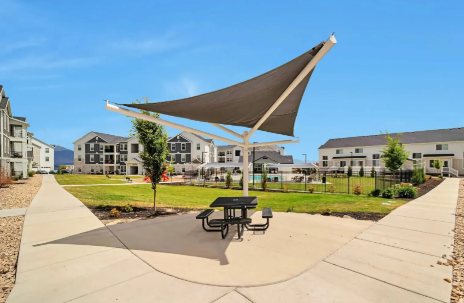 Centrally located community green space with a shade structure and paved walkways