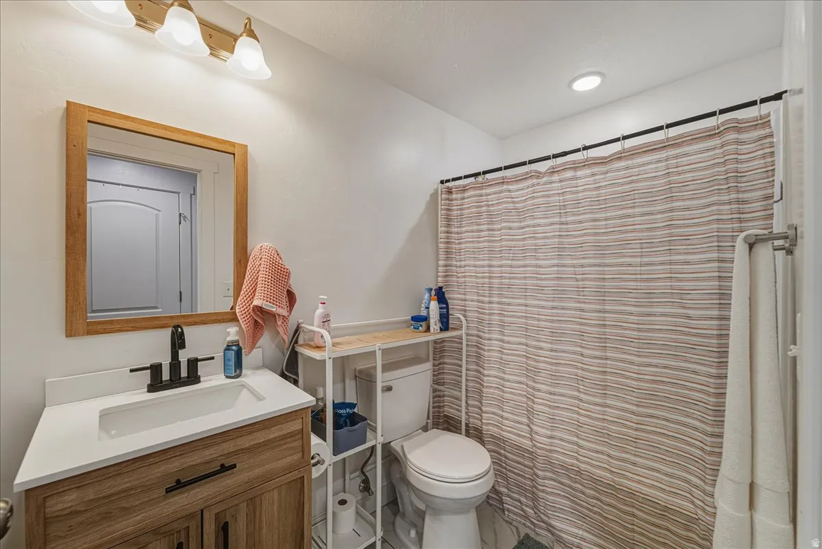 Bathroom featuring a wood-frame vanity with integrated sink, matte black faucet, and a wall-mounted mirror