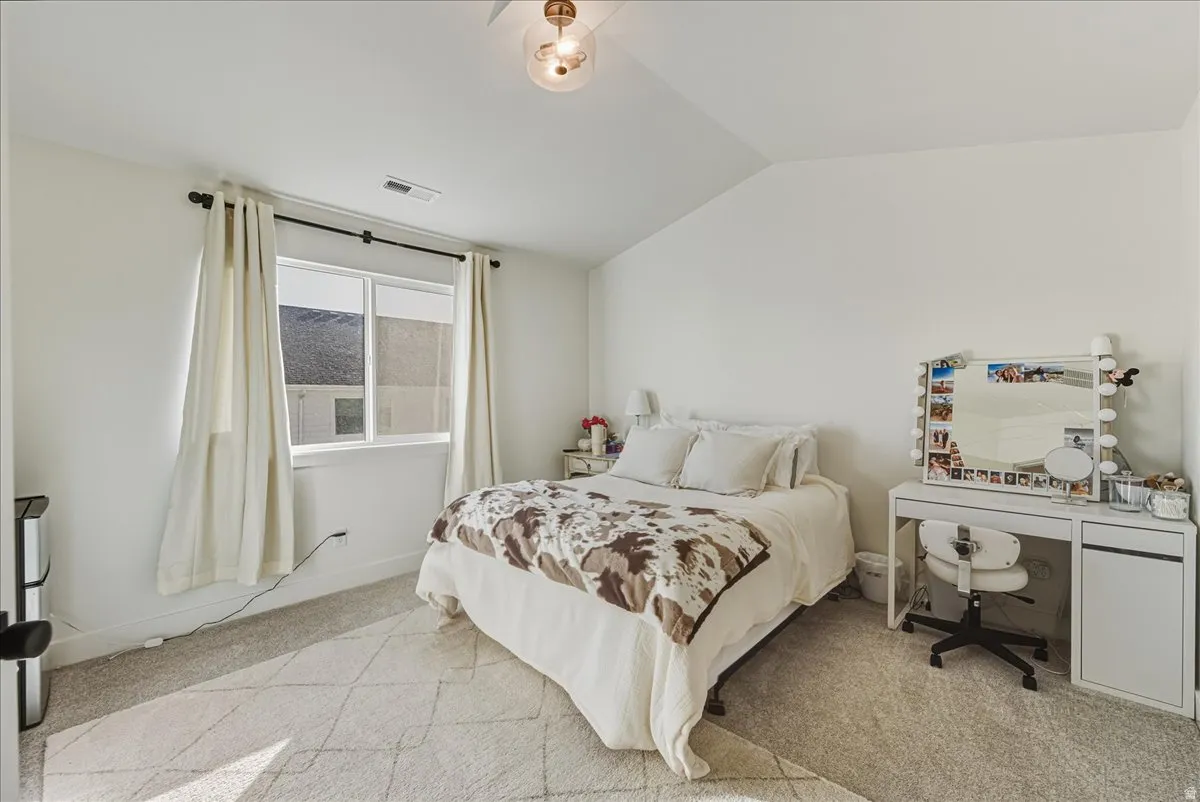 Vaulted ceiling, light-toned carpeting, window with blinds, recessed lighting, and a contemporary ceiling light fixture