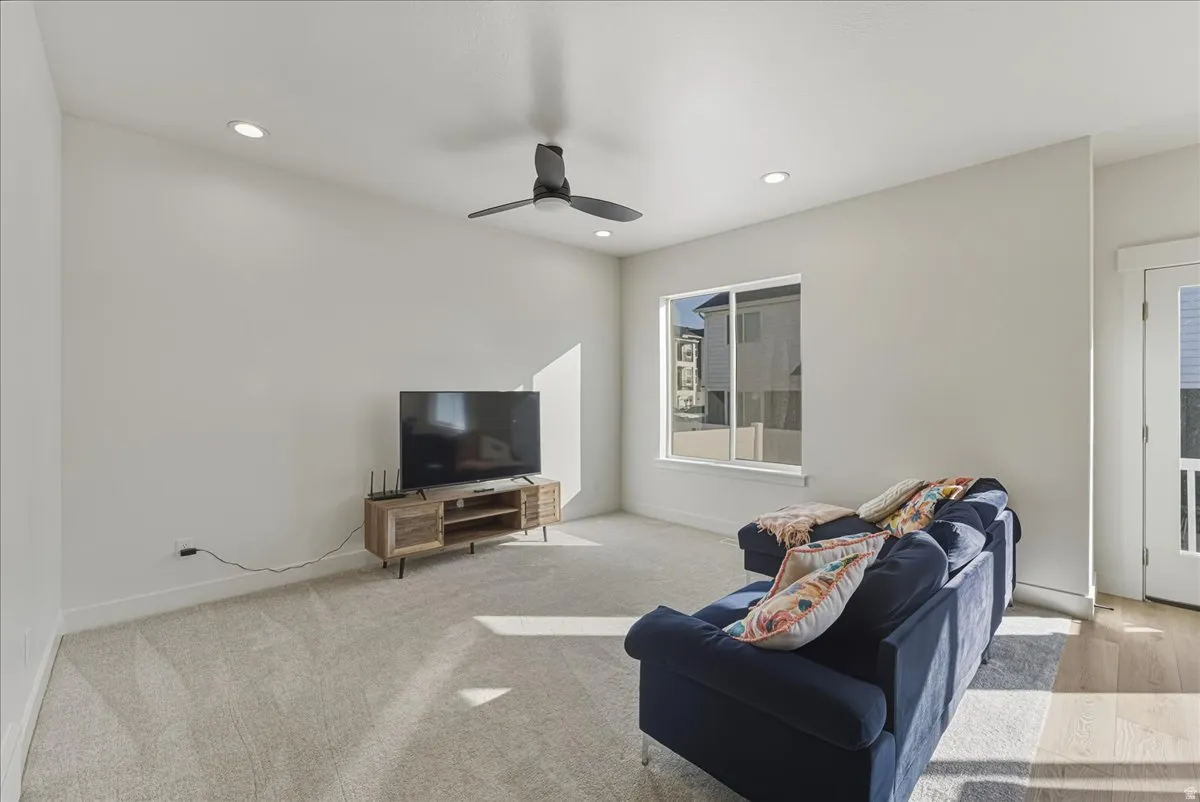 Recessed lighting, ceiling fan, carpeting, natural light, and a door with an upper glass pane