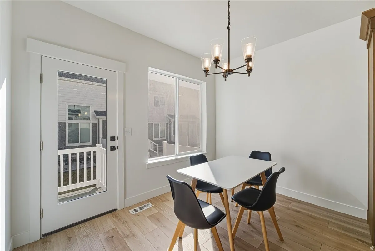 Wood-finish flooring, white walls, and a contemporary chandelier