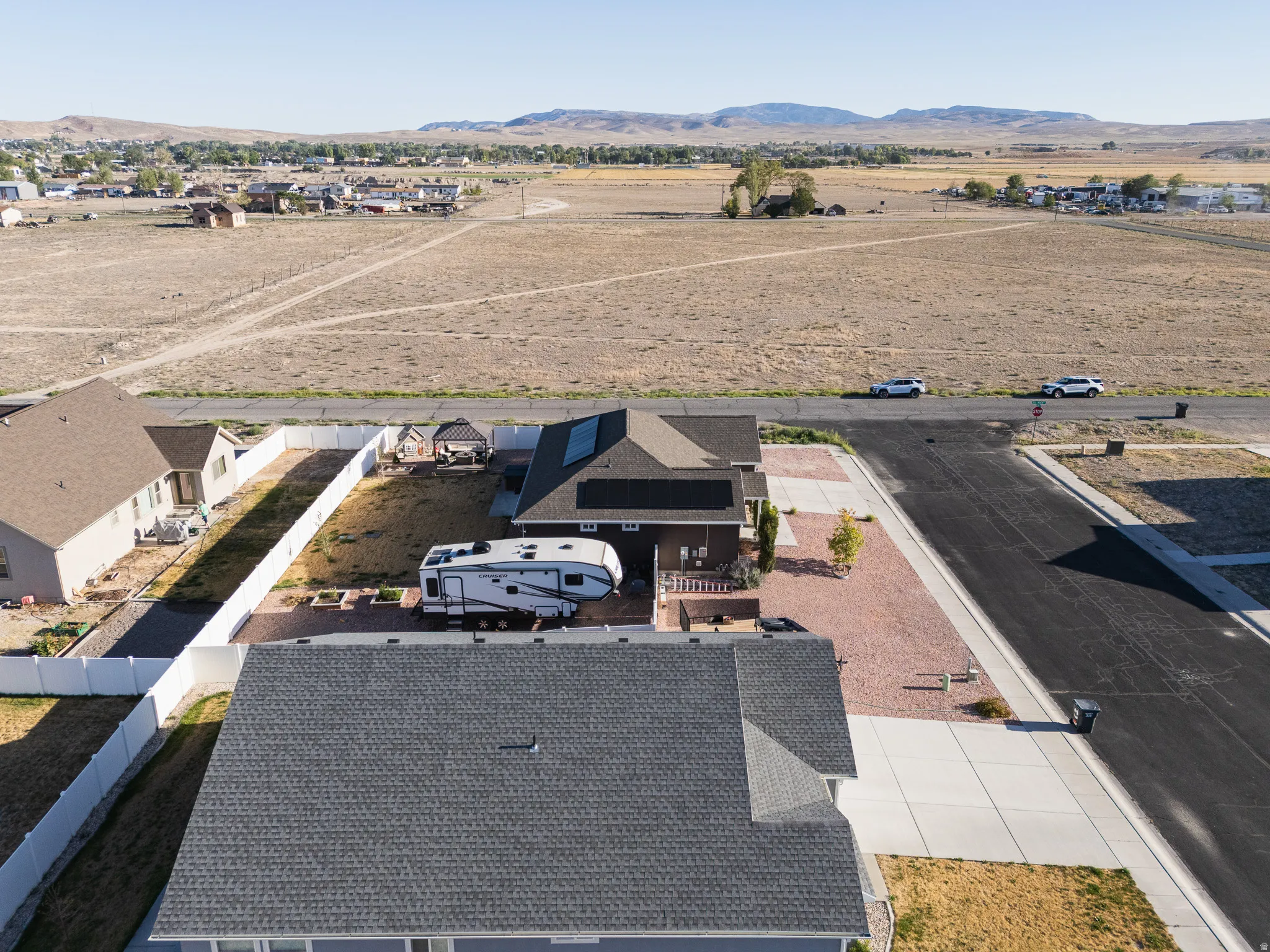 Expansive property featuring a paved driveway, a gazebo, and a fenced yard