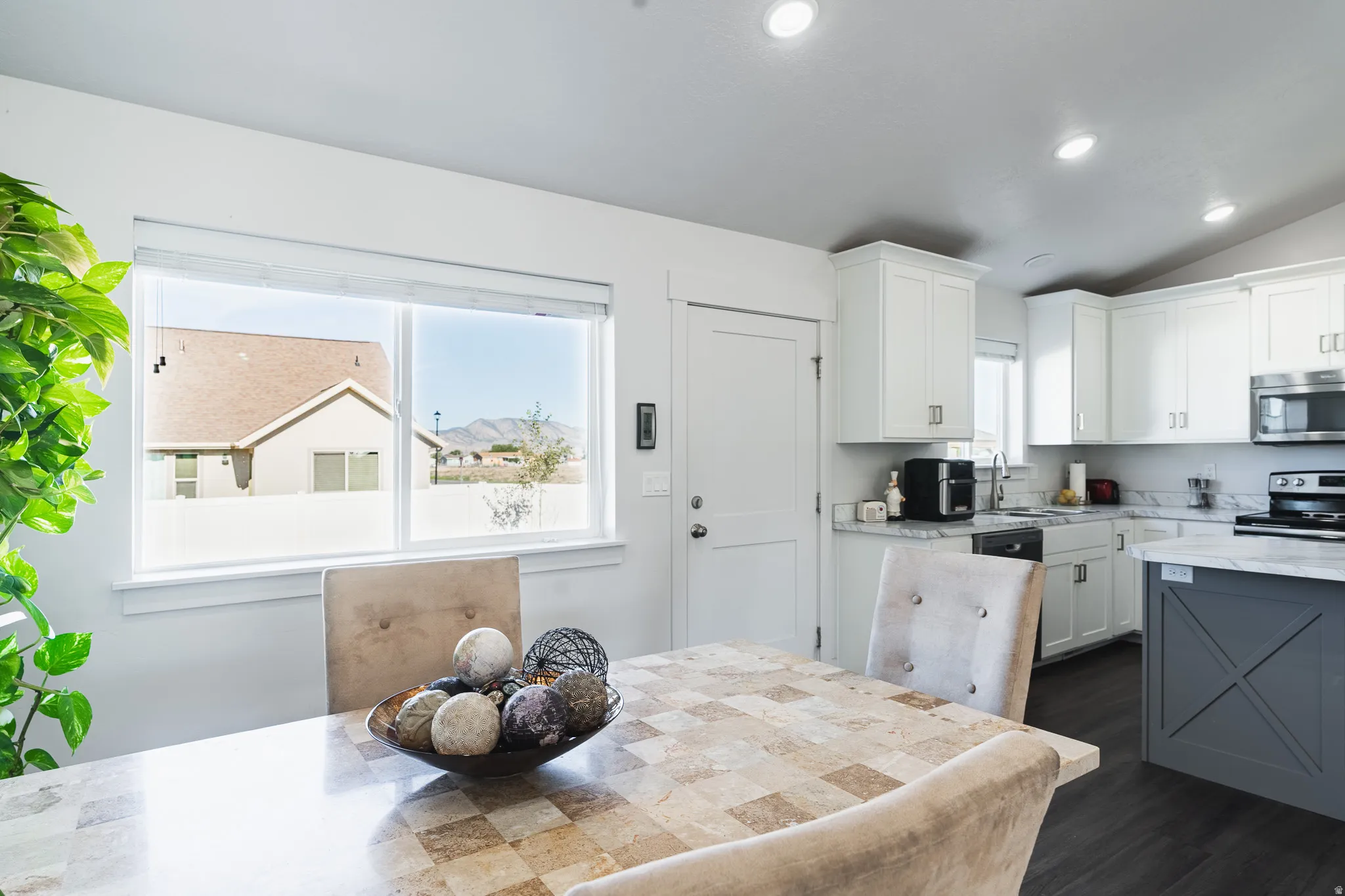 White shaker cabinetry, recessed lighting, stainless steel appliances, dark wood-finish flooring, and white countertops