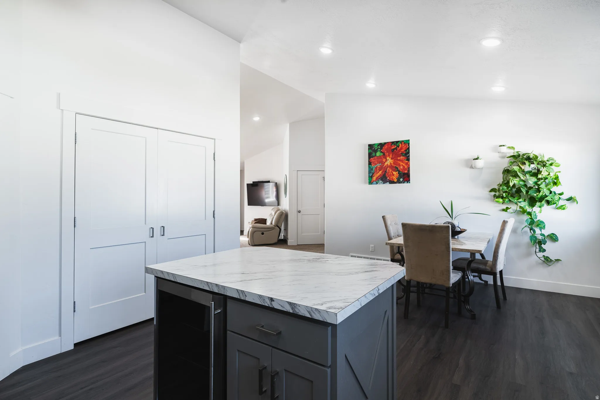 Kitchen island with a light-toned marble-finish countertop and dark cabinetry