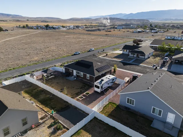 Fenced property with a dark shingle roof and solar panel installation